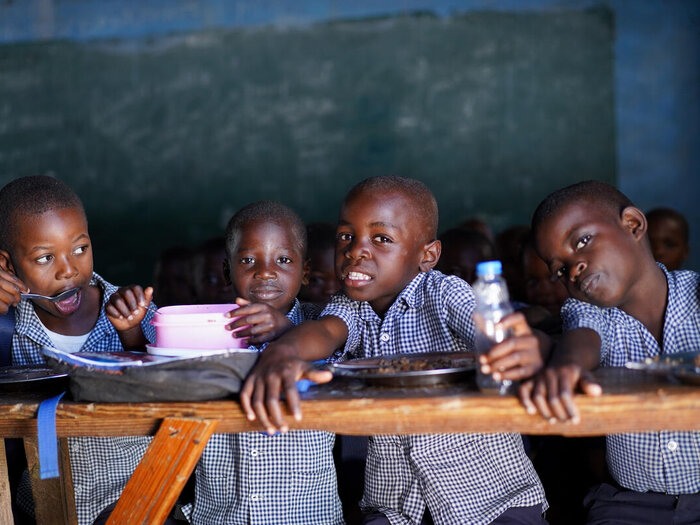 neljä lasta istuu luokkahuoneessa
